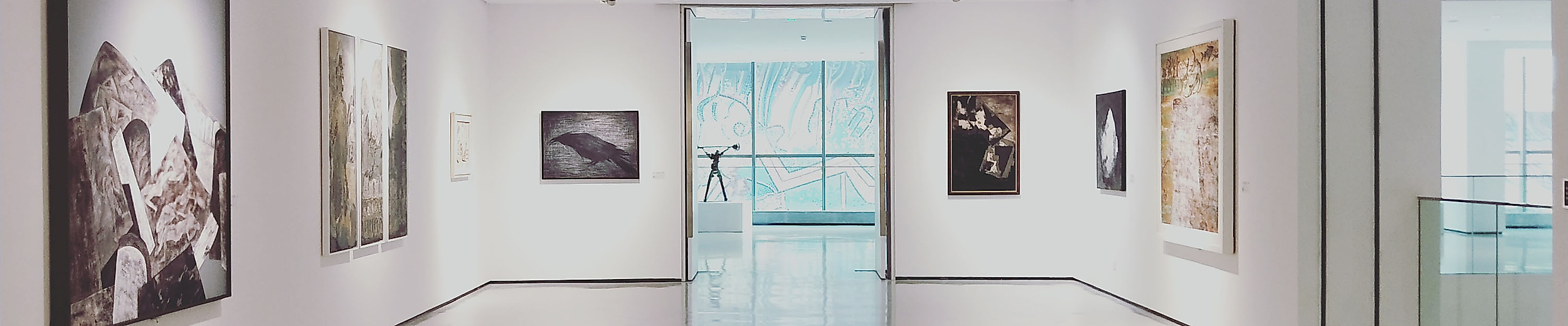 Heller Galerieraum mit modernen Gemälden an weißen Wänden und glänzendem Boden