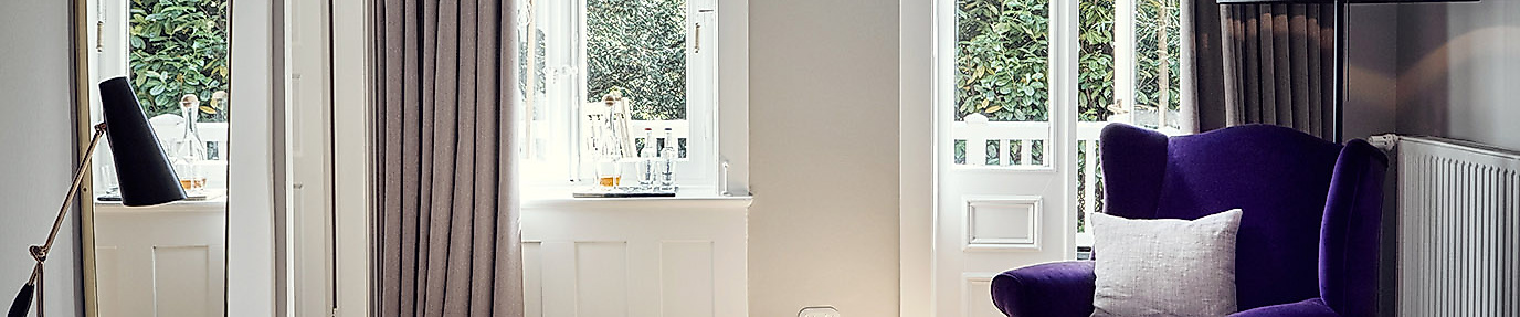 Helles Zimmer im Landhaus Flottbek Hamburg mit skandinavischem Design und gemütlichem Sessel