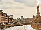 Abendstimmung in der Hamburger Speicherstadt mit Blick auf Kanal, historische Gebäude und Kirchturm