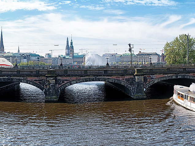 Panoramablick auf die Kennedybrücke in Hamburg mit Alsterbooten und Skyline im Hintergrund