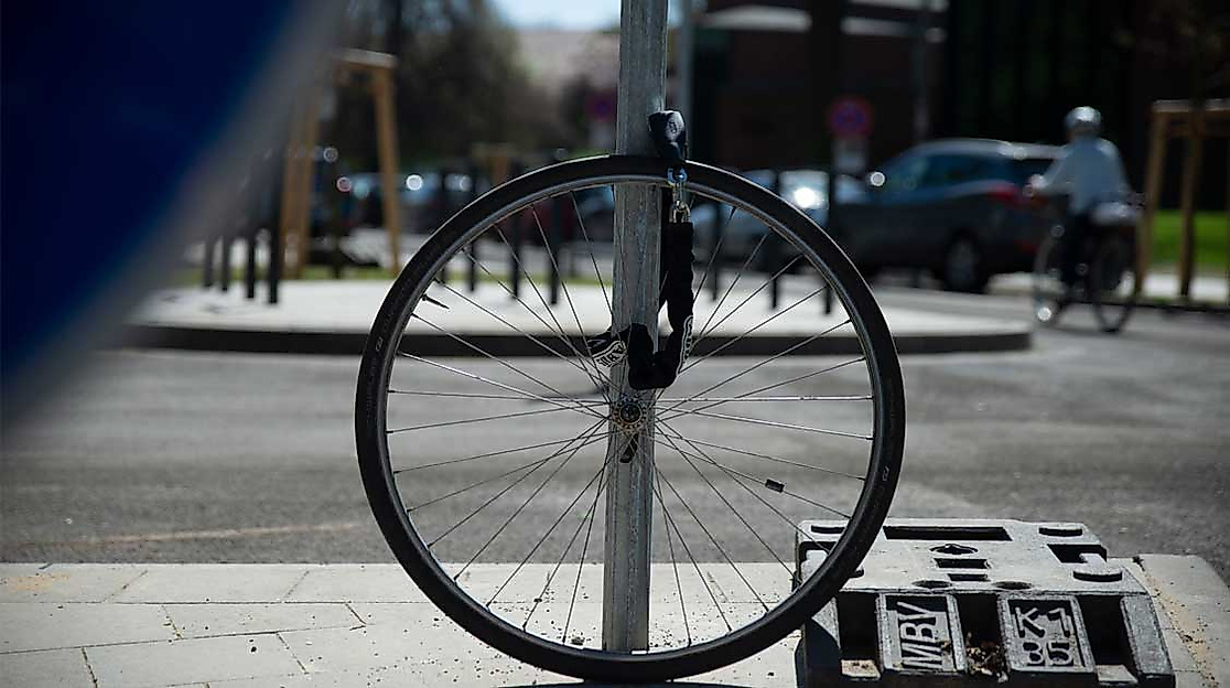 An Laternenmast abgeschlossenes, gestohlenes Fahrrad mit nur noch dem Vorderrad am Schloss