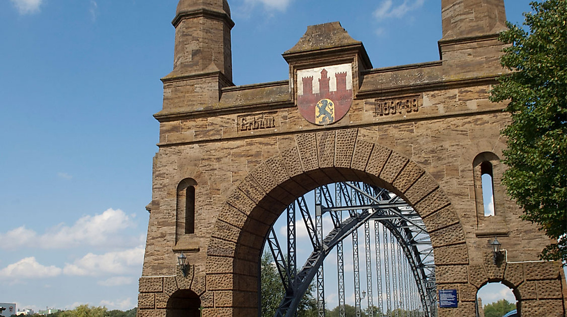 Alte Elbbrücke in Hamburg-Harburg mit historischem Brückentor und Blick auf die Stahlbogenkonstruktion bei Sonnenschein