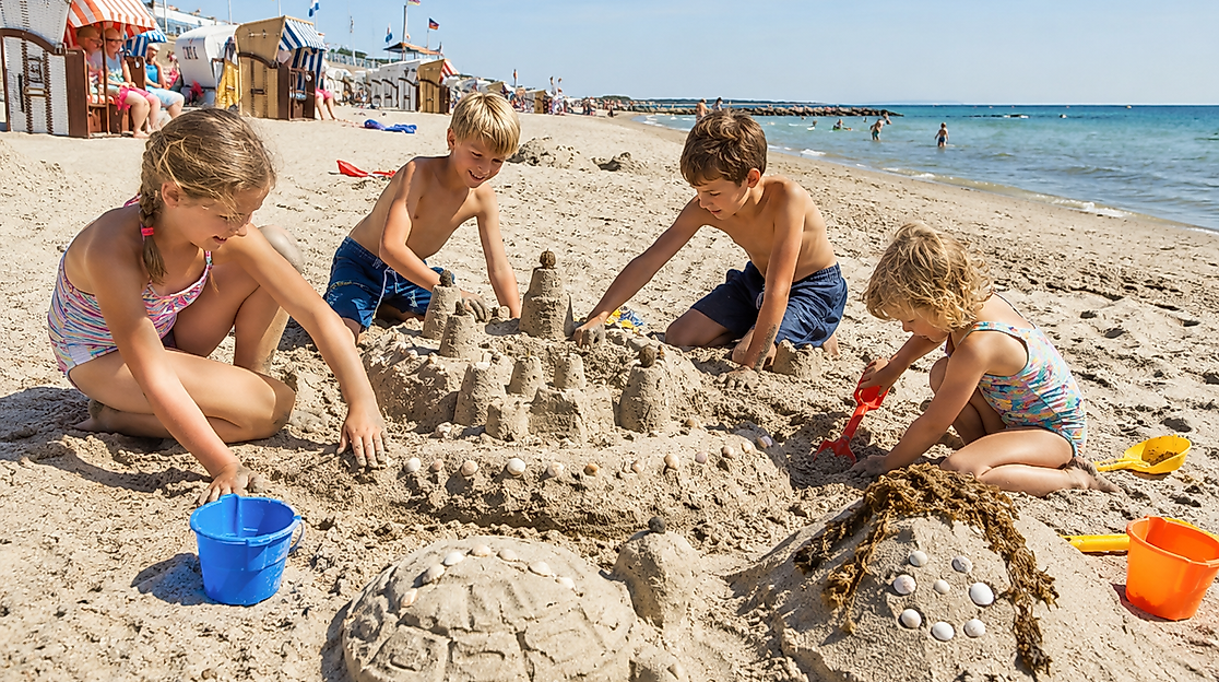 Kinder bauen Sandburg am Strand