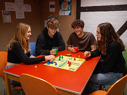 Jugendliche spielen Mensch-Ärgere-Dich-Nicht