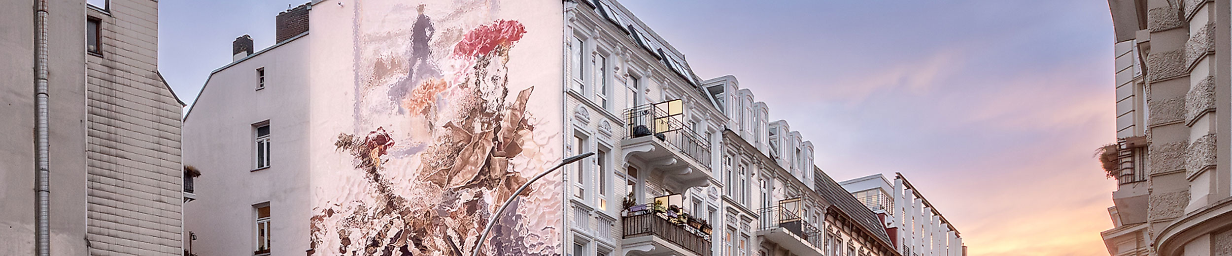 Mural nach Caspar David Friedrich an weißer Hausfassade in Hamburger Wohnstraße bei Abendstimmung