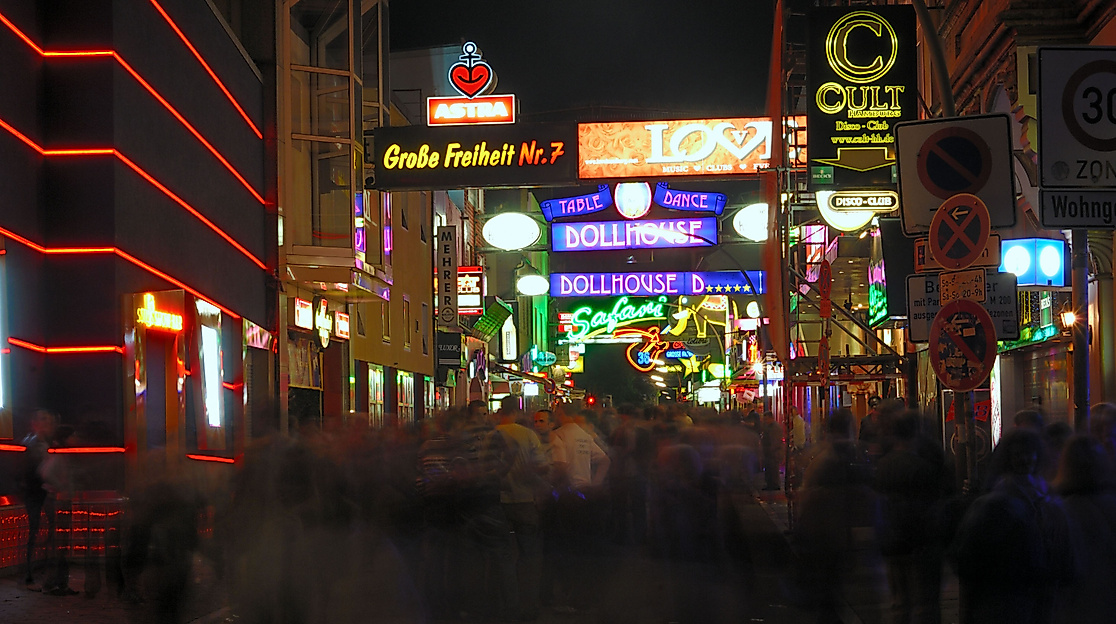 Leuchtende Reeperbahn bei Nacht mit bunten Neonreklamen und Menschenmenge