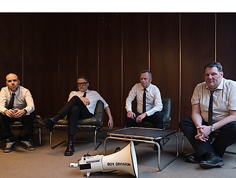 Die vier Mitglieder von Boy Division tragen alle ein weißes Hemd und eine schmale, schwarze Krawatte; sie sitzen lässig in einem Konferenzzimmer im Stil der 60er, vor ihnen liegt ein weißes Megafon, beschriftet mit dem Namen der Band.