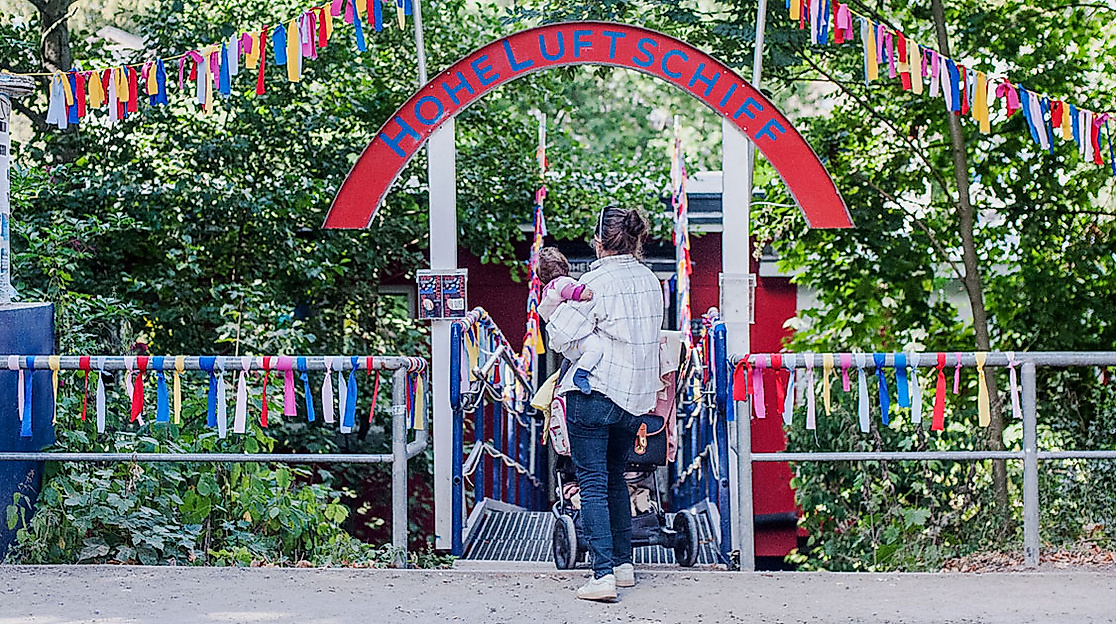 Mutter mit Kind auf dem Arm vor dem Hoheluftschiff in Hamburg