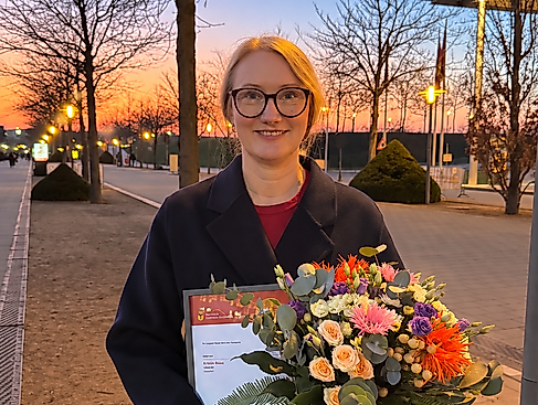 Person mit Blumenstrauß bei Sonnenuntergang
