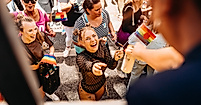 Fröhliche Menschen bei Hamburg Pride erhalten Getränke vom Wagen – queere Sichtbarkeit und Lebensfreude