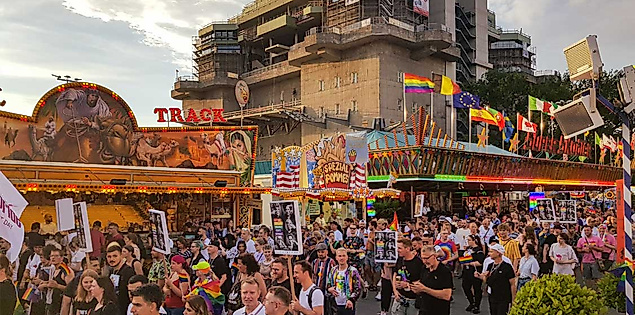 CSD-Demo auf dem Hamburger Dom mit Schildern, Regenbogenfahnen und queerer Sichtbarkeit zwischen Fahrgeschäften