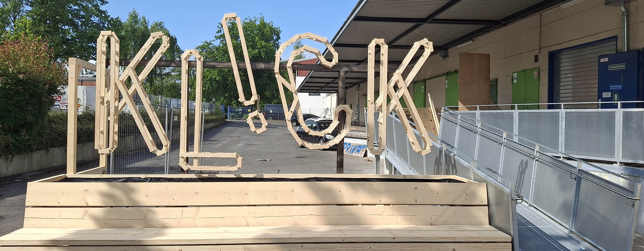 Holzinstallation 'KLICK' vor Gebäude