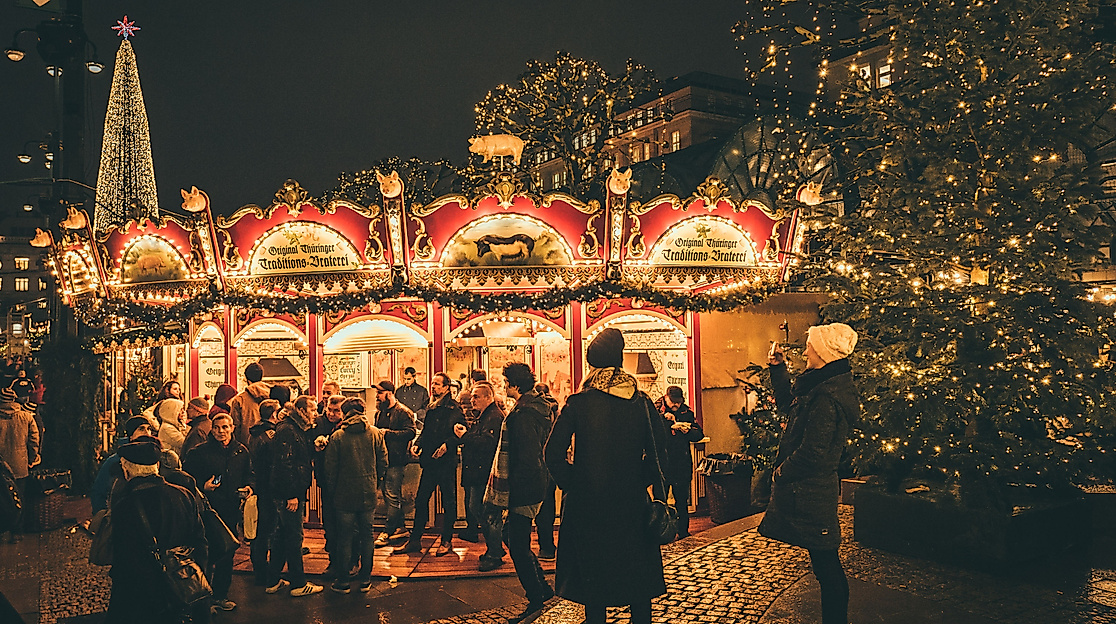 Illuminated carousel and festively decorated Christmas tree at the Christmas market at night